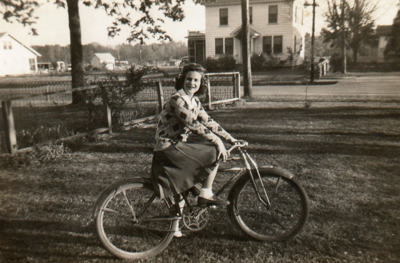 edith-chapman-on-bike-with-christopher-house-in-background-img063